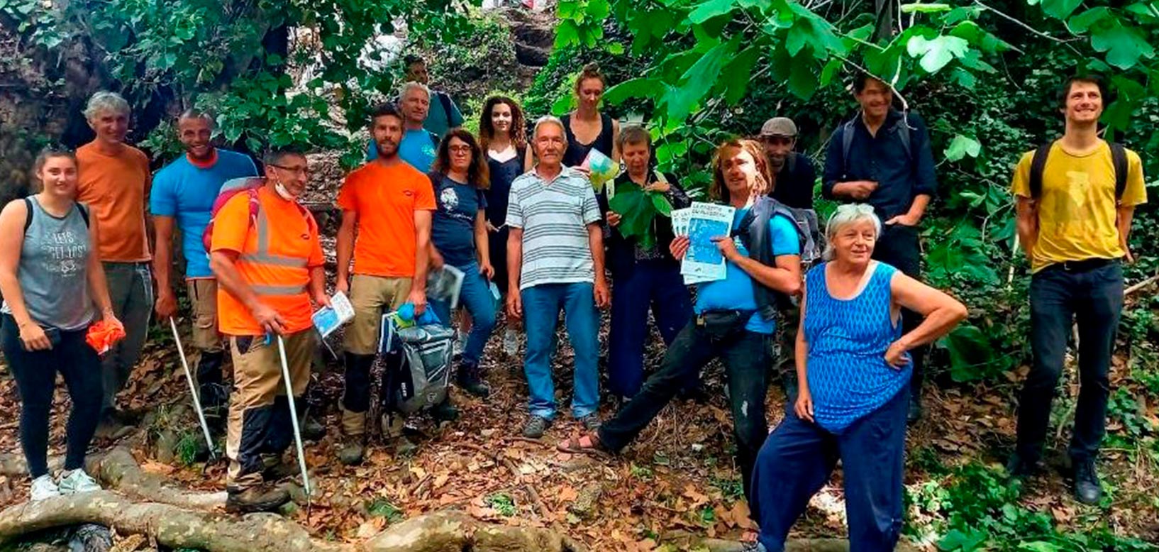 Un groupe d'agents et de bénévoles posent en forêt lors d'une opération de nettoyage ou de sensibilisation à l'environnement.