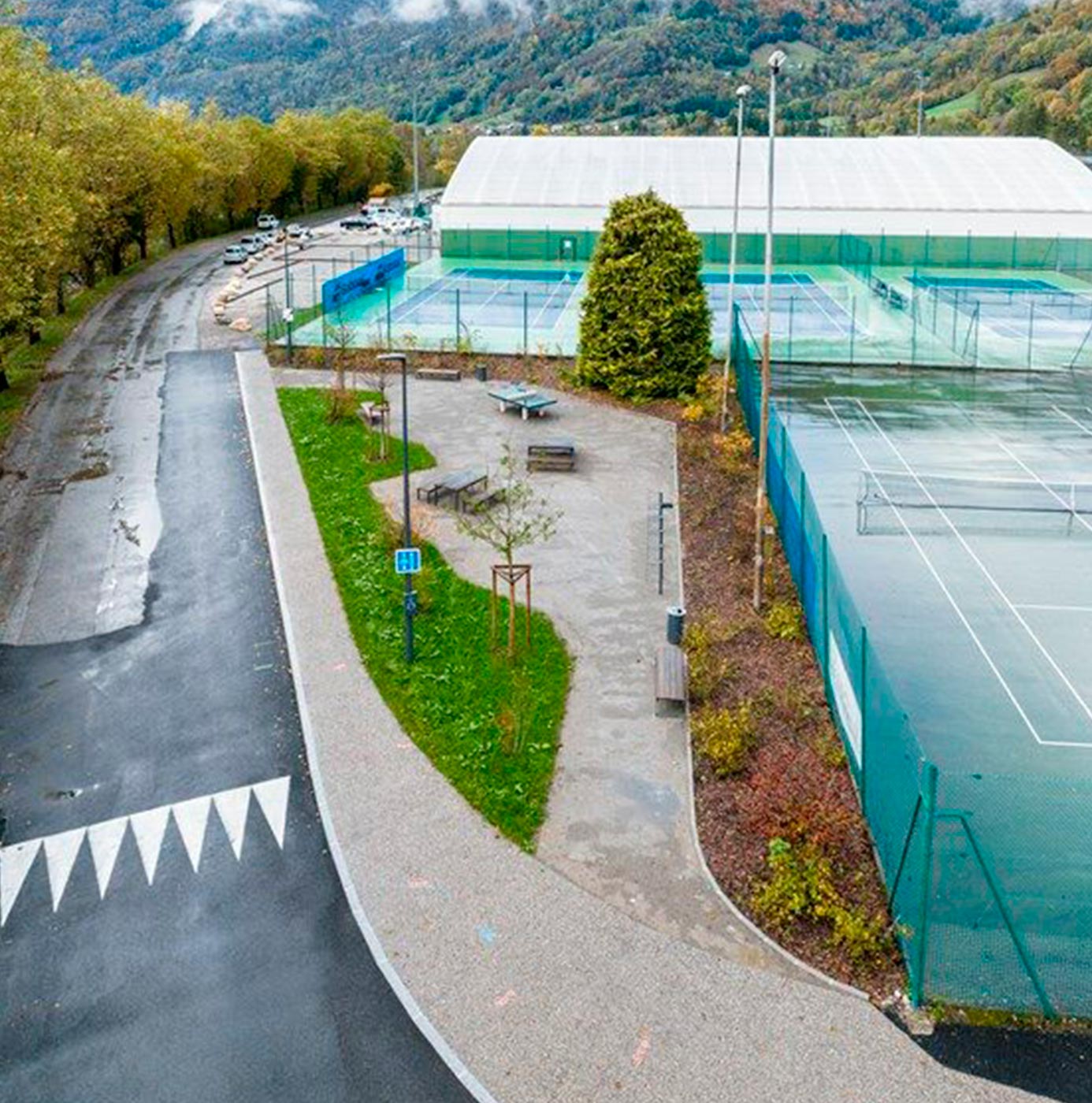Vue aérienne d'un complexe de courts de tennis avec ses espaces verts et abords paysagers aménagés.