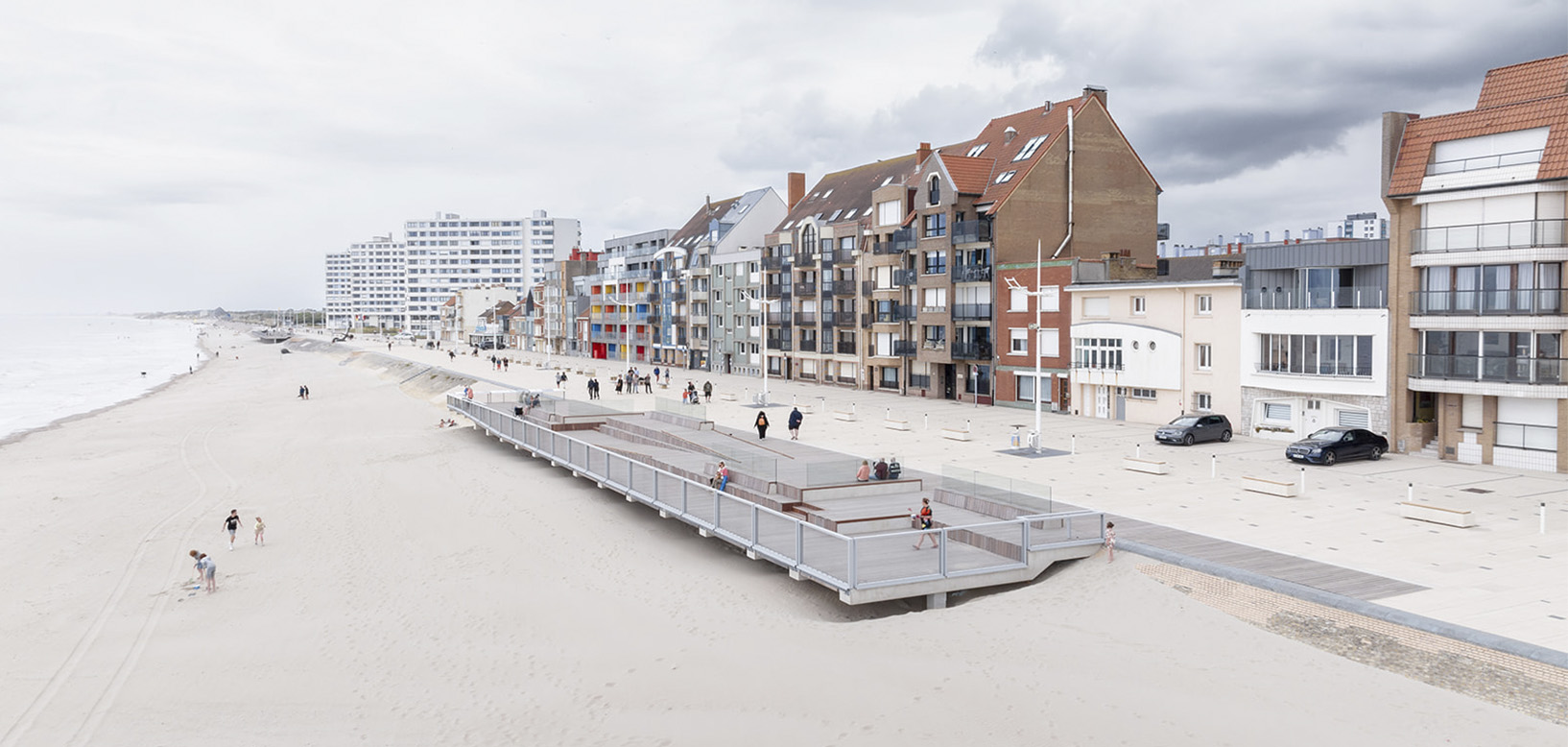 Promenade en bois aménagée en surplomb d'une plage face à un front de mer urbain.
