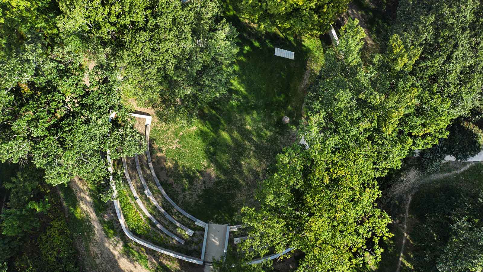 Vue aérienne d'un amphithéâtre en bois entouré d'arbres dans un espace vert urbain