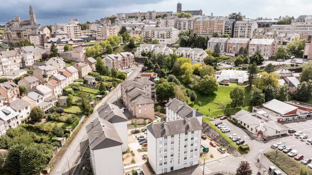 Vue aérienne d'une ville française avec espaces verts urbains, immeubles résidentiels et cathédrale en arrière-plan