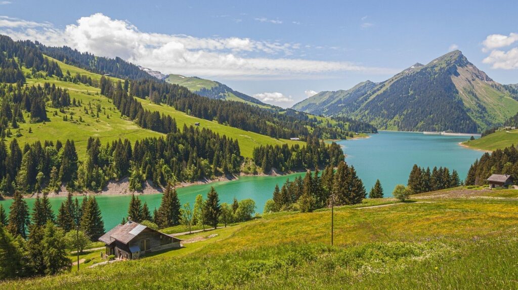 Lac de montagne turquoise entouré d'alpages et de chalets