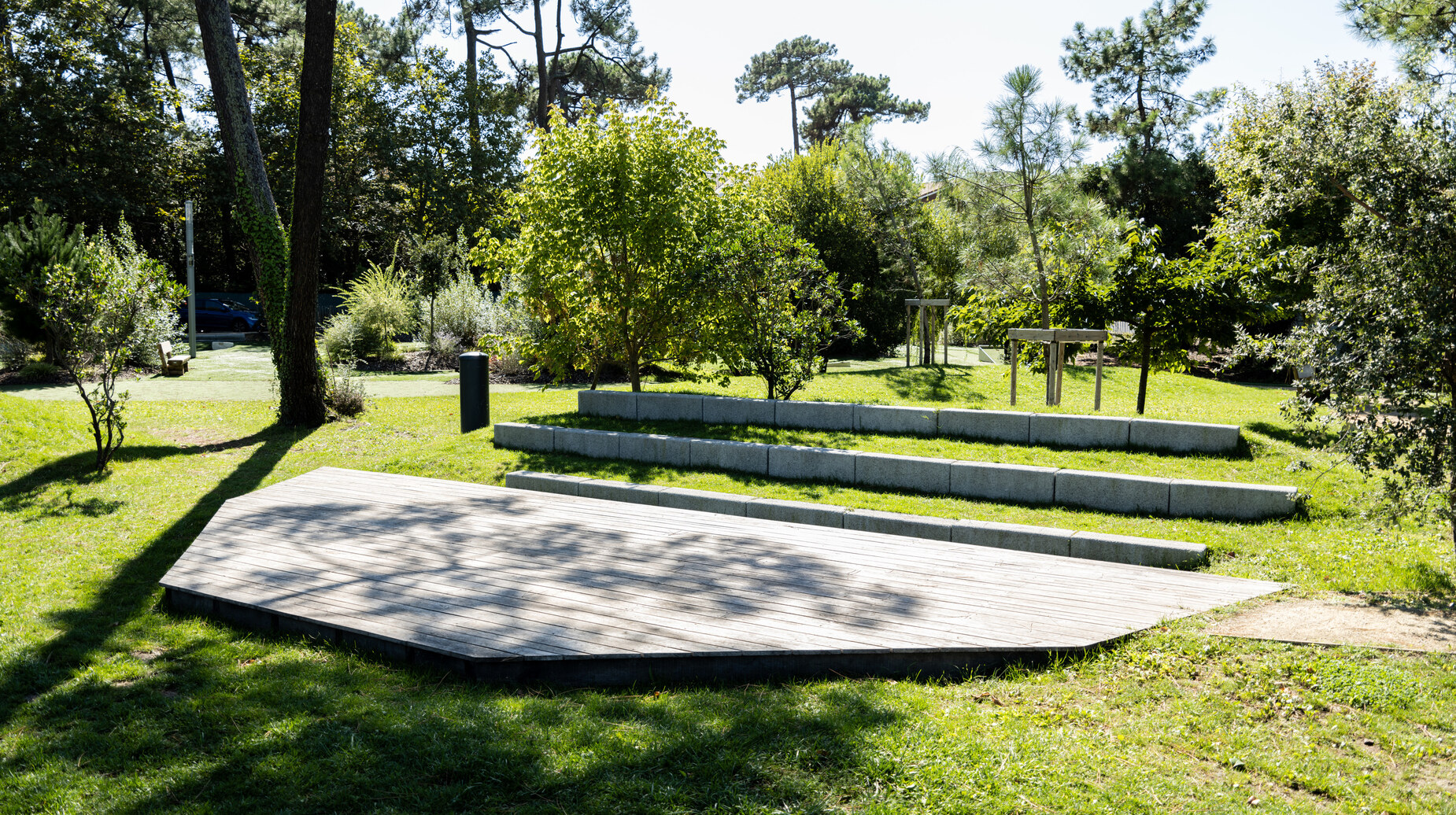 Gradins en bois installés sur une pelouse ombragée dans un parc