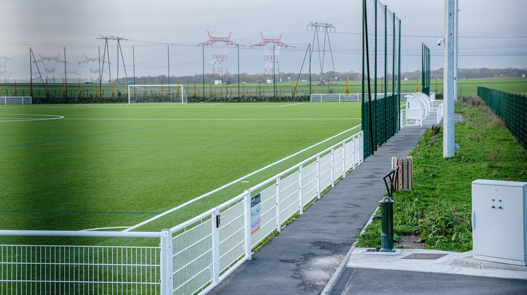 Terrain de football en gazon entouré de clôtures et de pare-ballons
