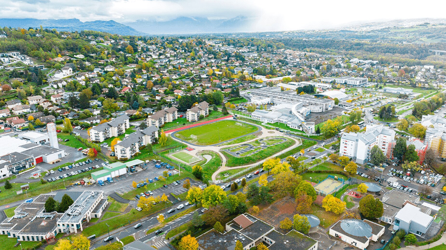 Vue aérienne d'une ville de taille moyenne entourée de collines boisées