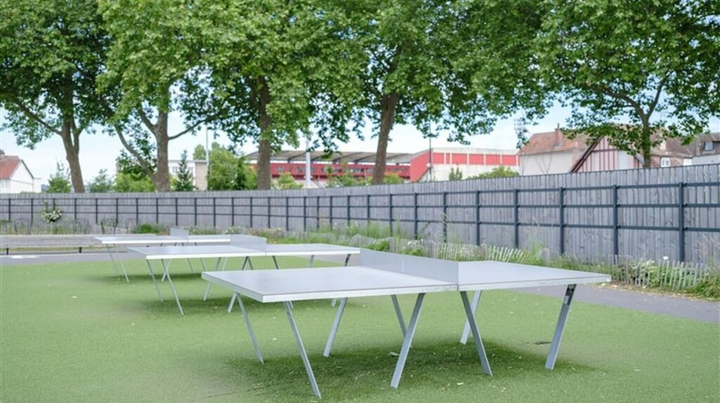 Tables de tennis de table en extérieur sur sol souple à l'ombre des arbres