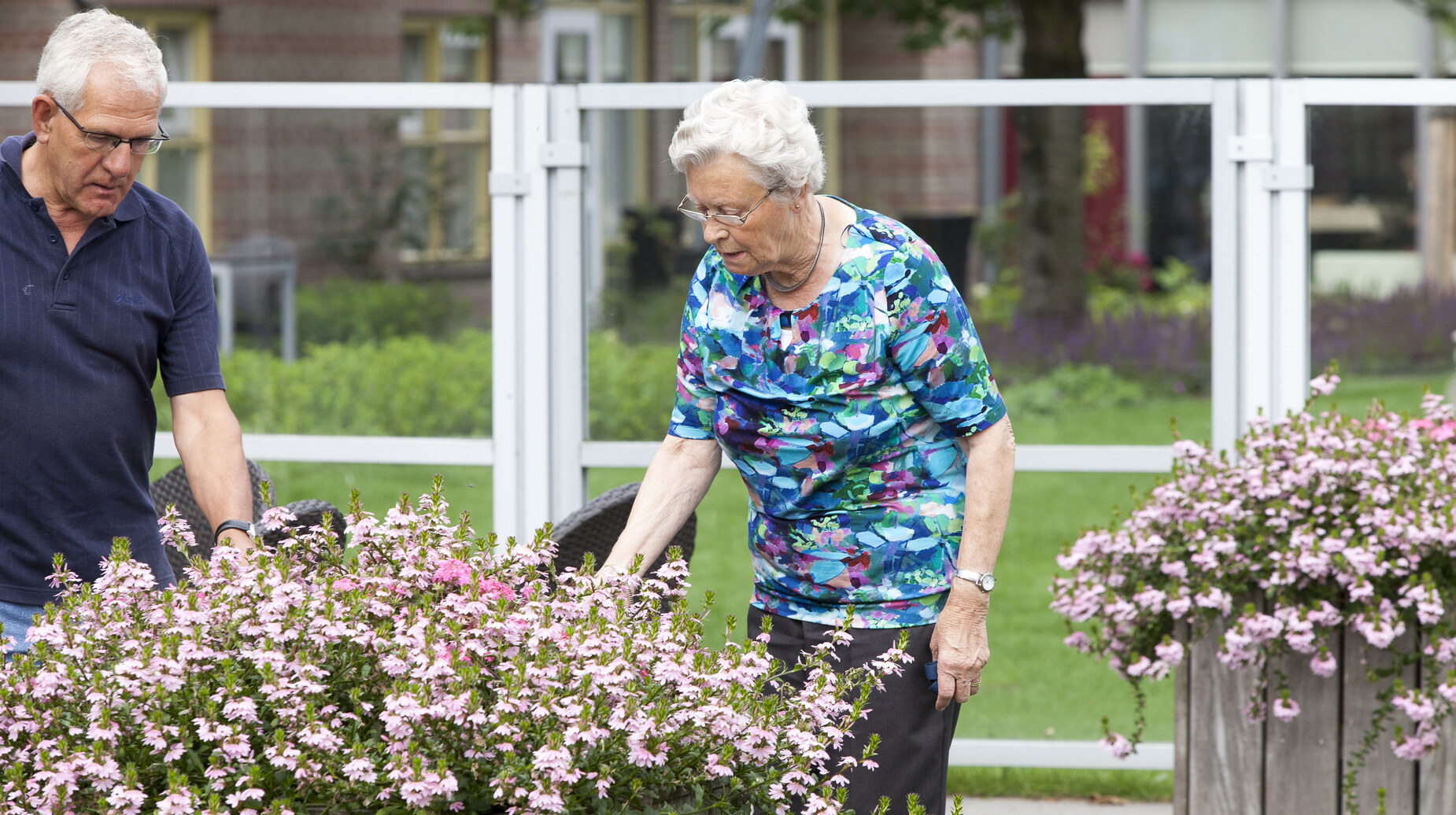 Personnes âgées jardinant dans des bacs surélevés fleuris