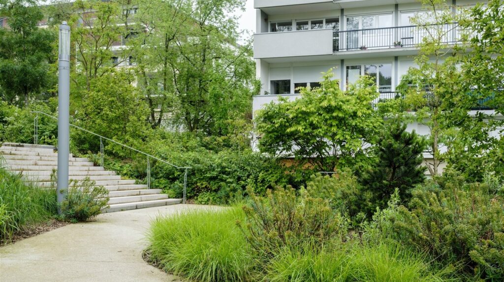 Escalier paysager bordé de graminées au pied d'un immeuble de logements