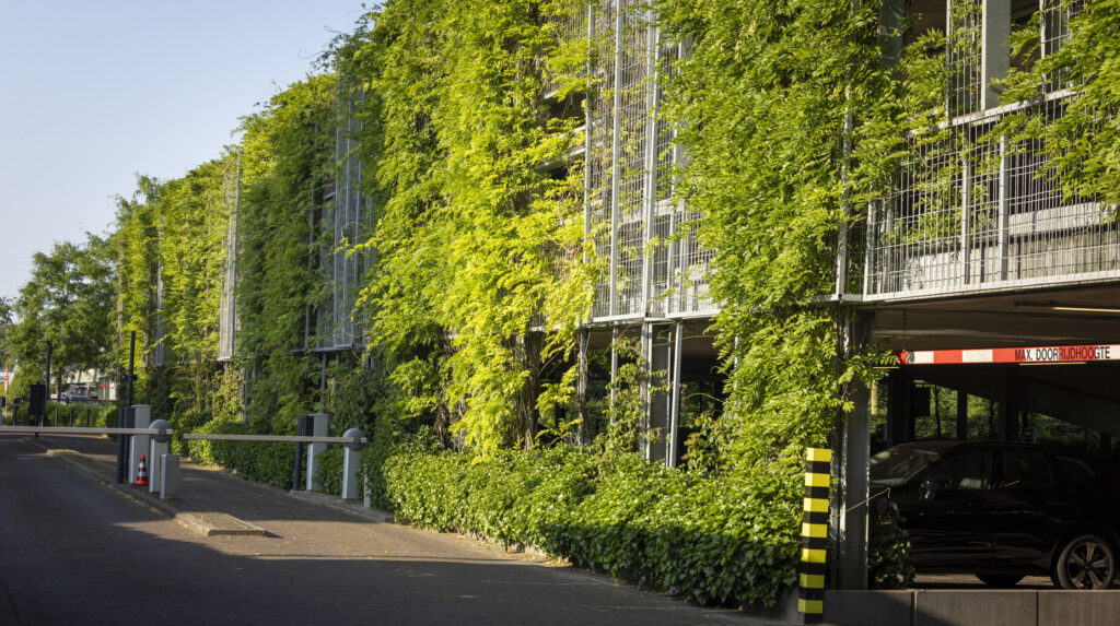 Façade de parking couverte d'un mur végétal luxuriant le long d'une voie