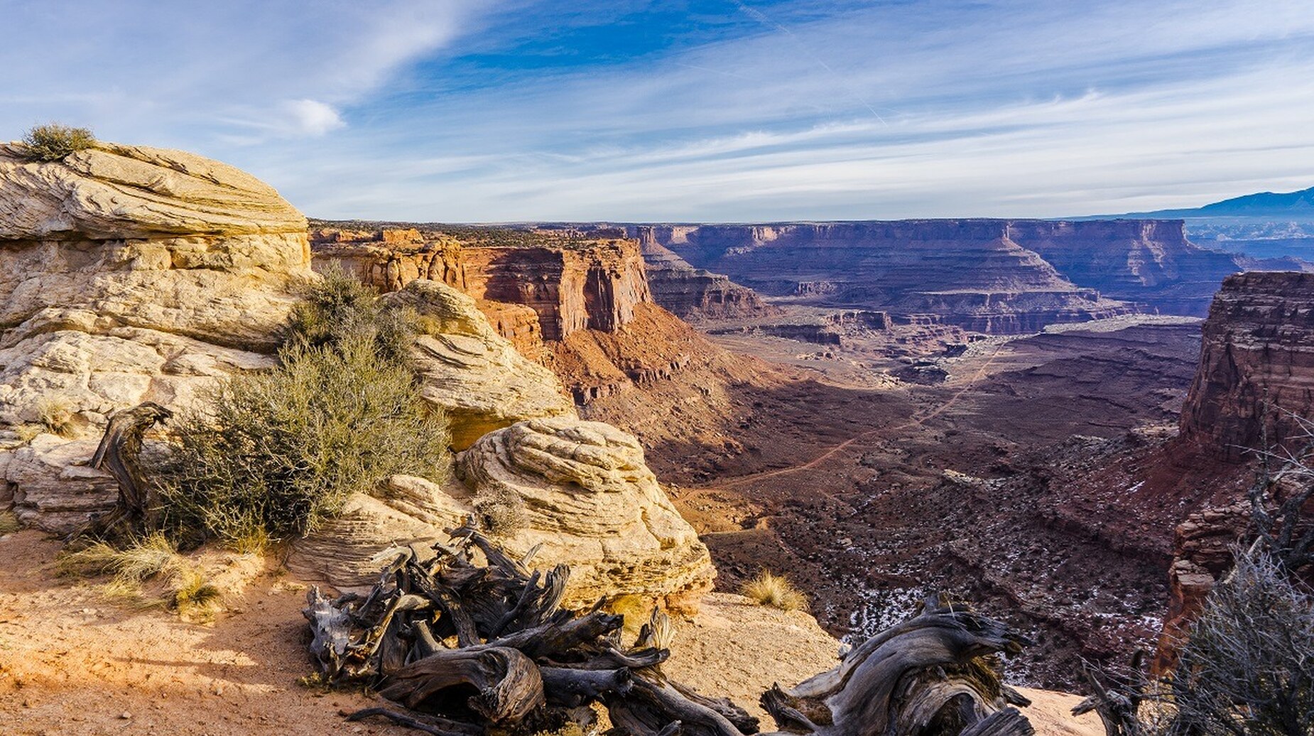 Canyon désertique aux strates rocheuses ocre sous un ciel bleu