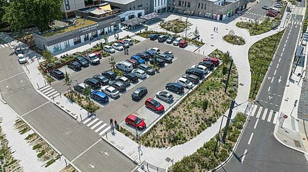 Vue aérienne d'un parking paysager avec noues plantées et cheminements piétons