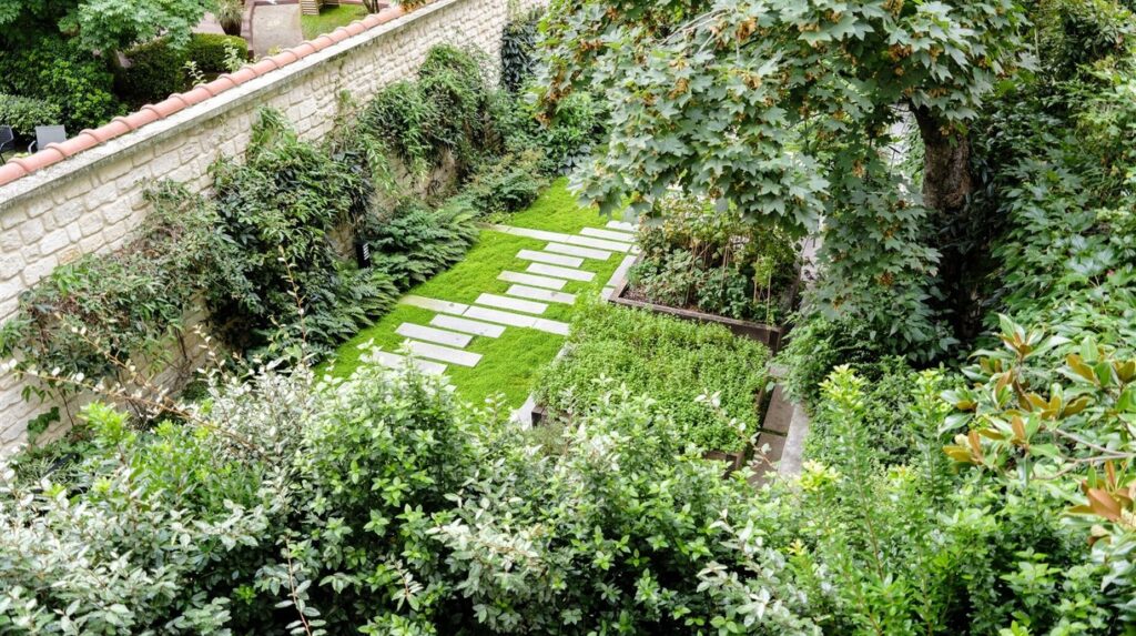 Jardin en terrasses très végétalisé avec cheminement en pas japonais
